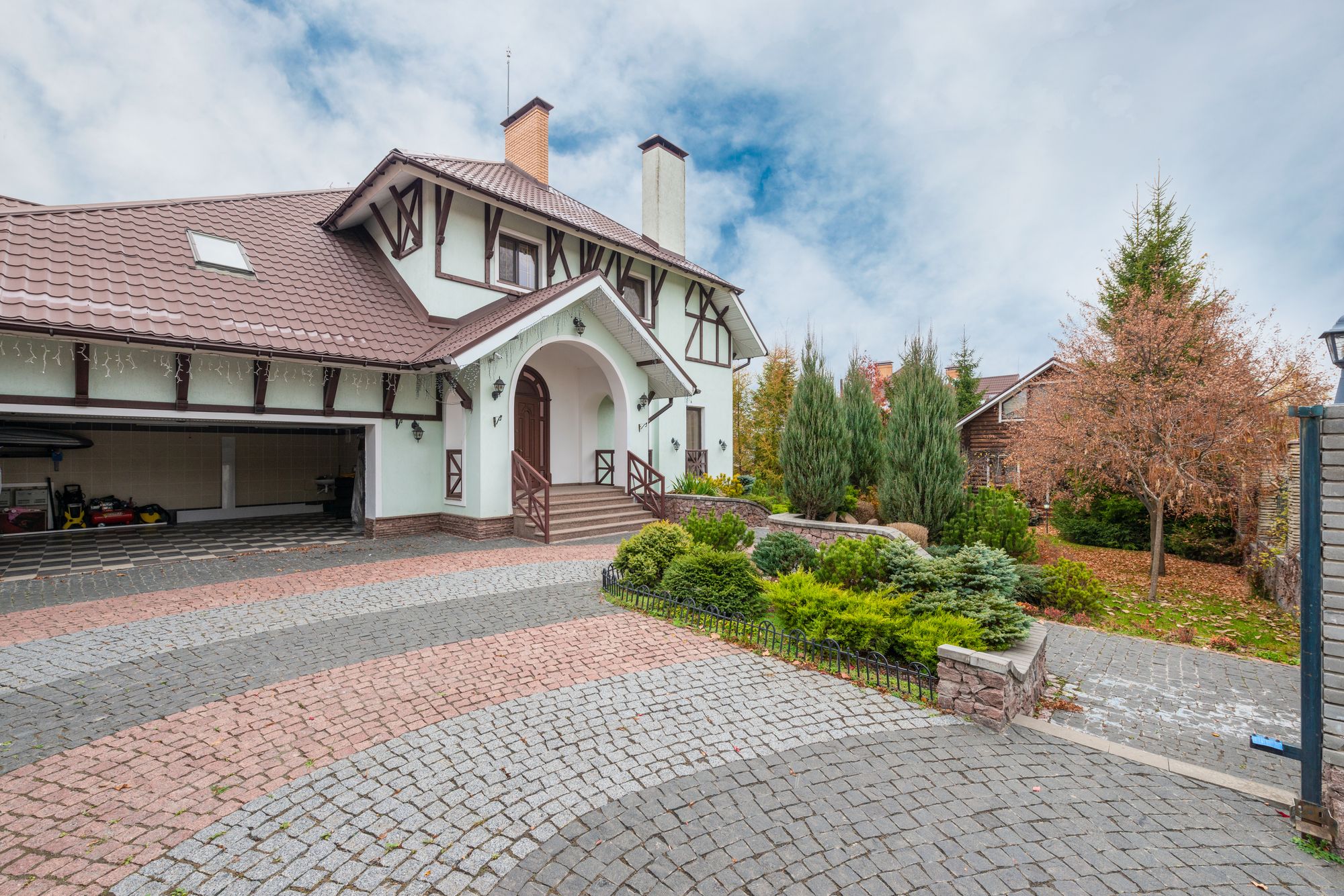 A cobblestone paver driveway leading to a house.