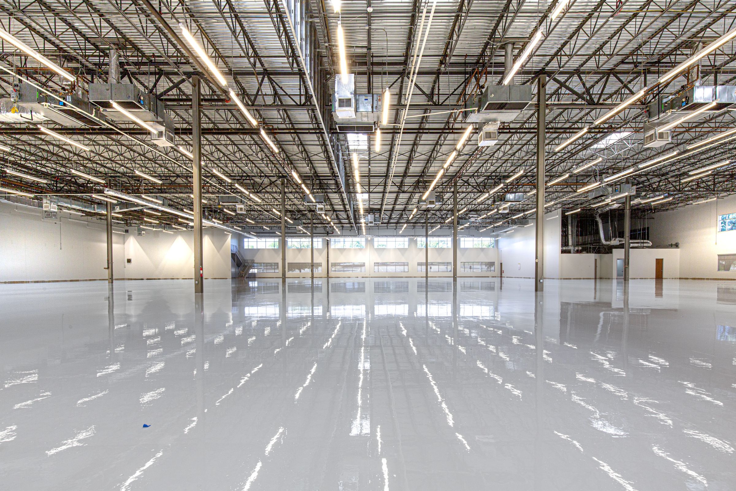 A high-gloss epoxy-coated floor reflecting overhead lighting.